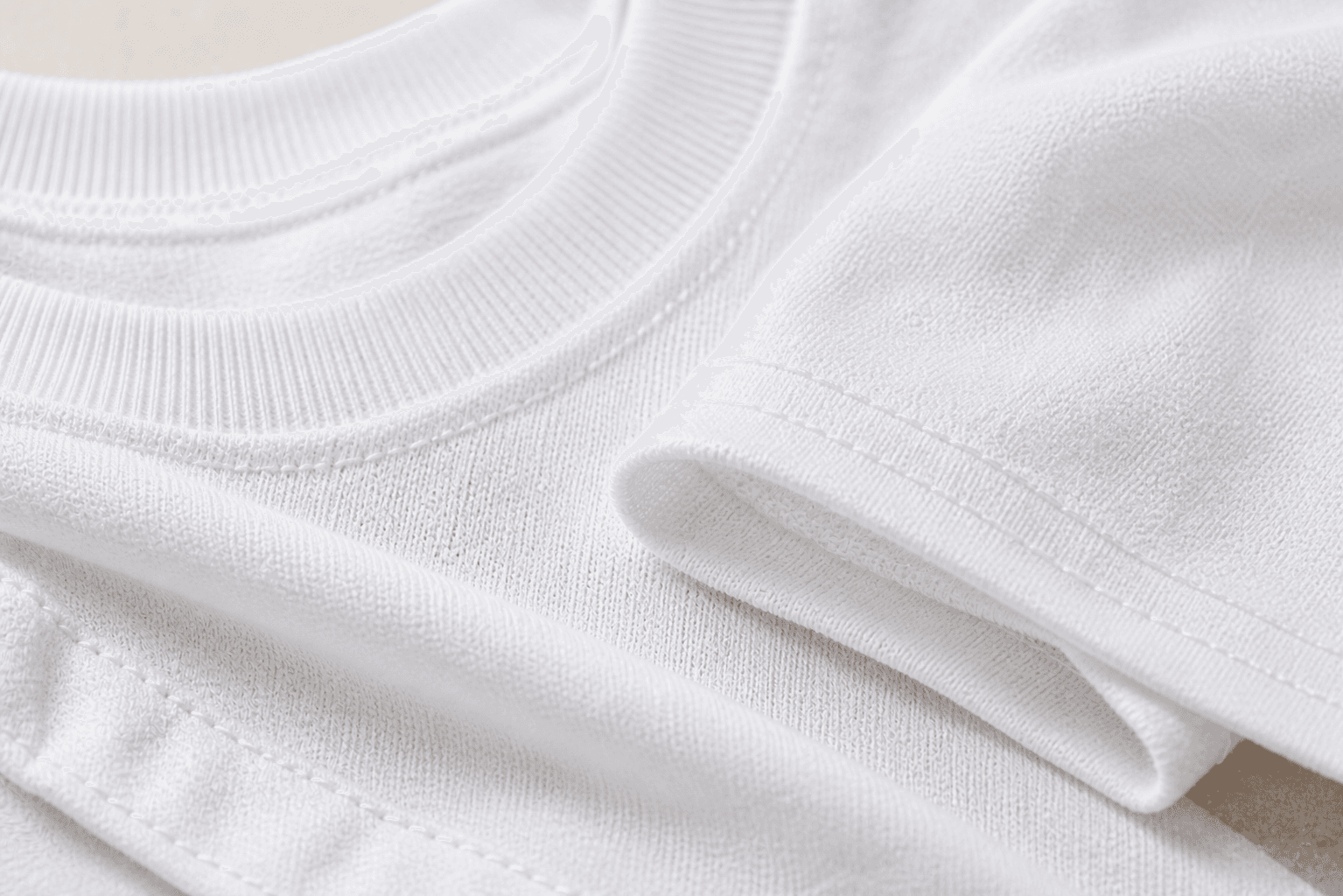 Close-up of The First Tee white T-shirt collar, sleeve, stitching, and fabric texture